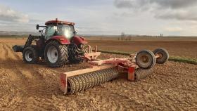 Un tractor en un campo de cultivo de alfalfa en Soria