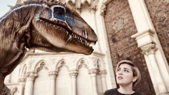 Un dinosaurio junto a una mujer