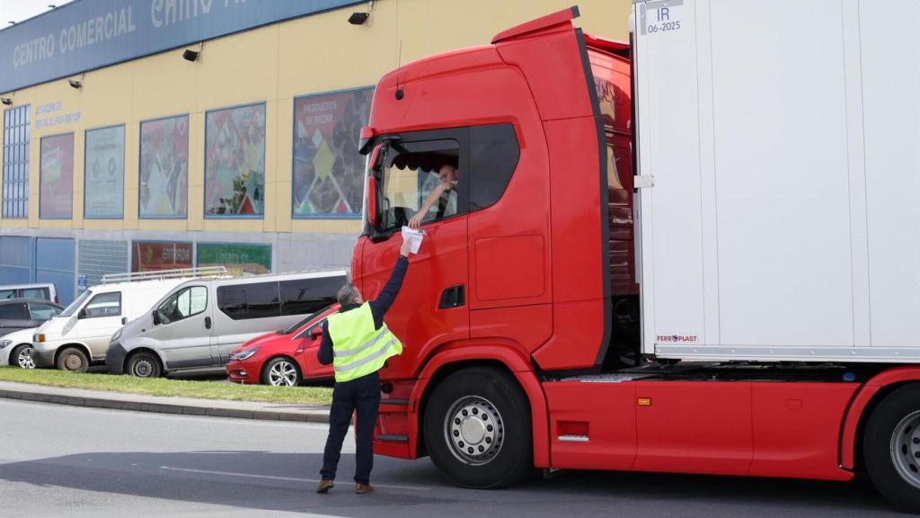 Un hombre entrega un papel a un transportista durante la convocatoria de paros en el transporte del pasado mes de marzo.