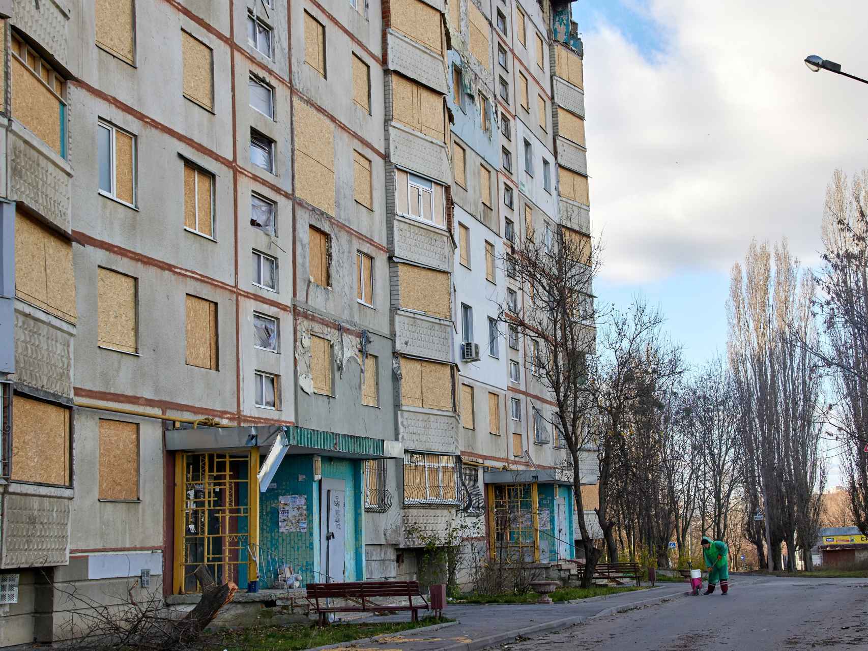 Un empleado municipal junto a un edificio residencial dañado en un bombardeo sobre Járkov.