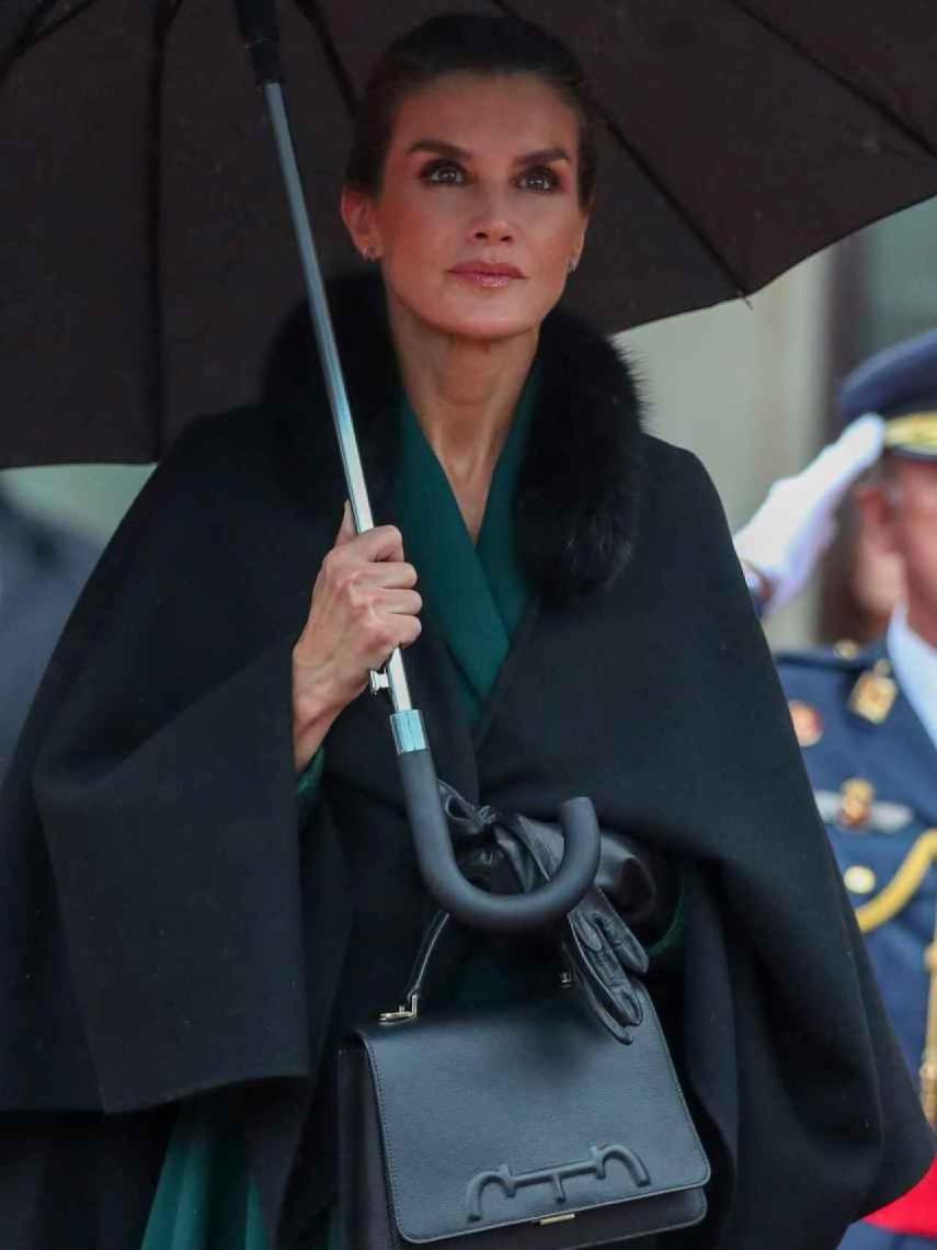 La Reina, protegida por un paraguas a su llegada.