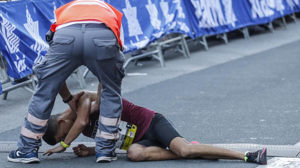 Efectivos de la Cruz Roja atienden a un corredor exhausto tras cruzar la linea de meta de la 57 edición de la Behobia-San Sebastián