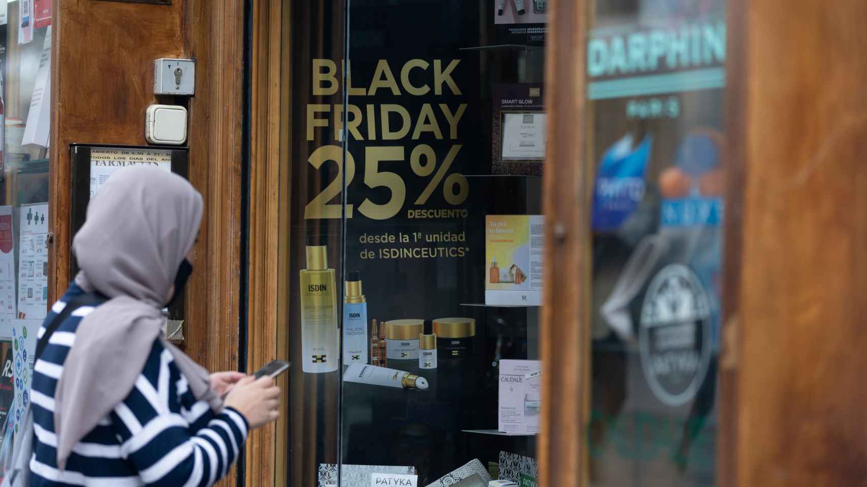Una persona pasa por delante de una tienda que anuncia un cartel publicitario del ‘Black Friday’.