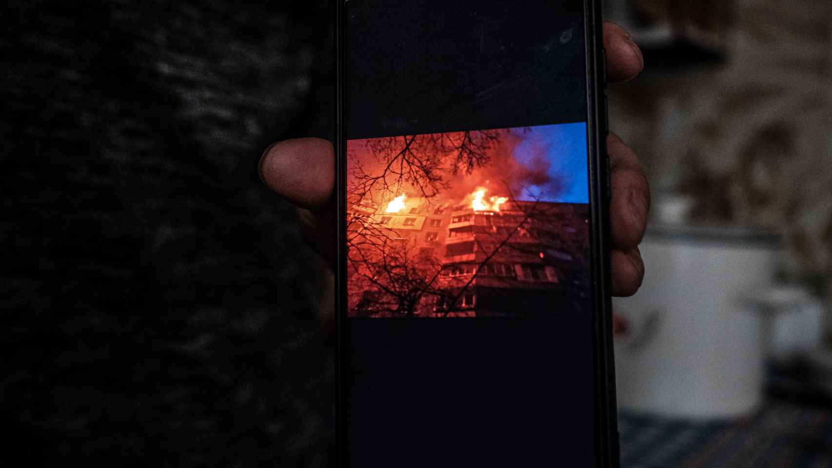 La familia de Katia muestra una foto de su casa de Saltivka envuelta en llamas tras ser bombardeada.