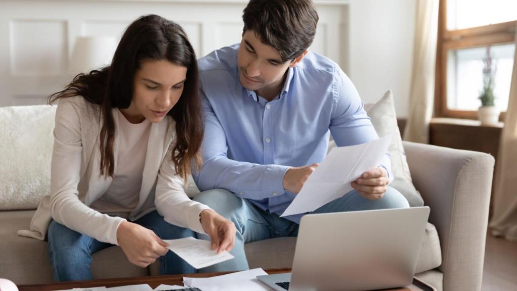 Una pareja mira los papeles para alquilar una vivienda.