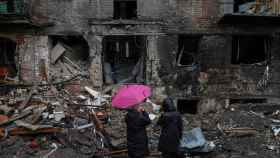 Residentes locales junto a su edificio destruido por un ataque de misiles rusos