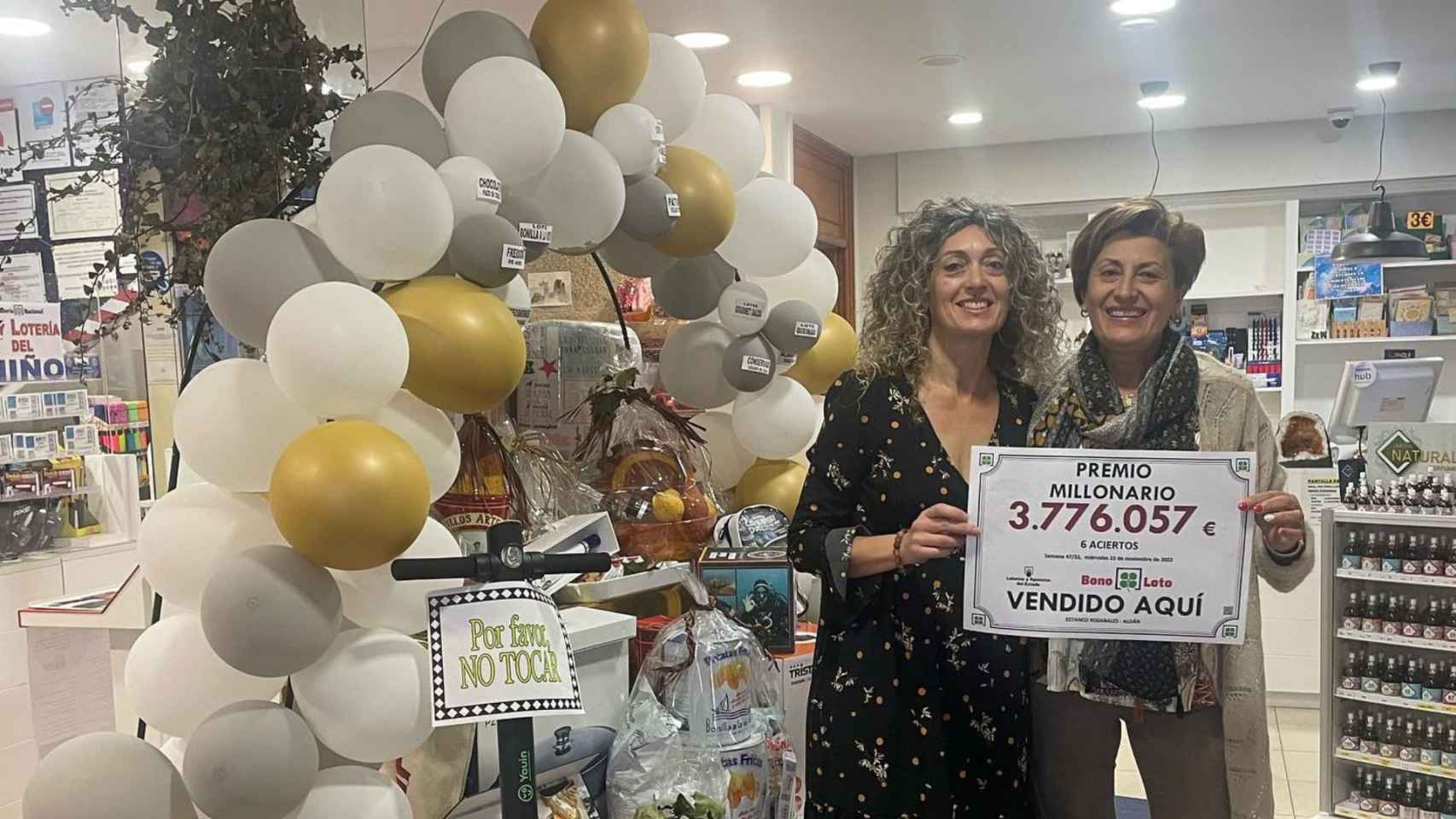 Chelo Millán y Nuria Piñeiro, trabajadoras del estanco, con el anuncio del premio.