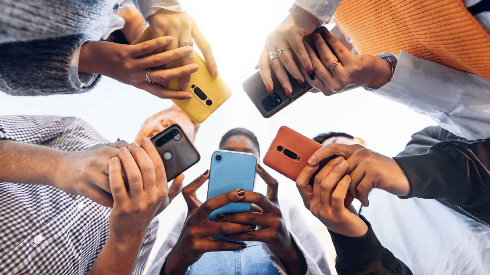 Foto de archivo de un grupo de personas usando el móvil.