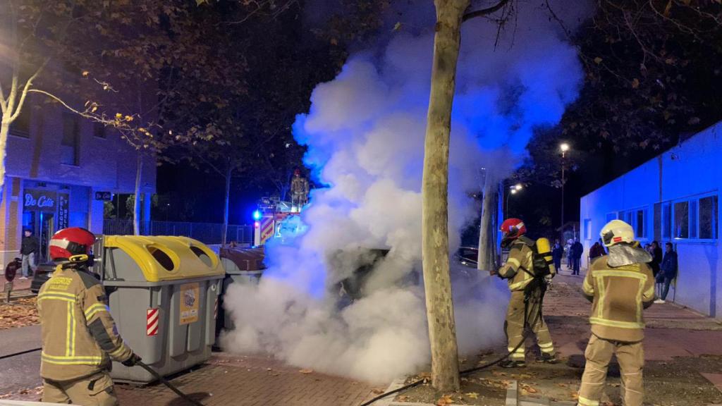 Los bomberos sofocan el fuego en un contenedor de papel en el barrio de Villa del Prado