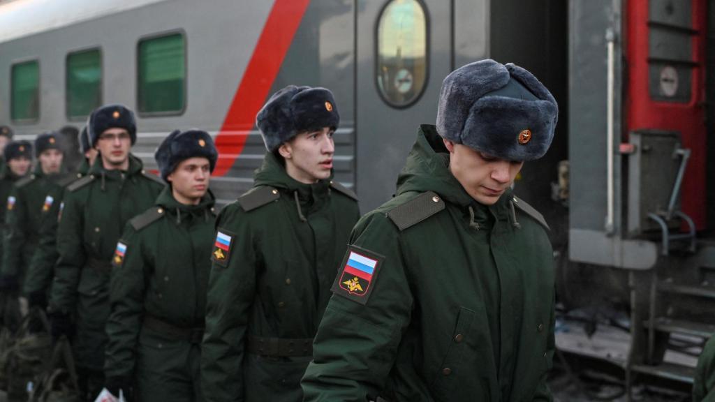 Los reclutas rusos llamados al servicio militar se alinean antes de subir a un tren