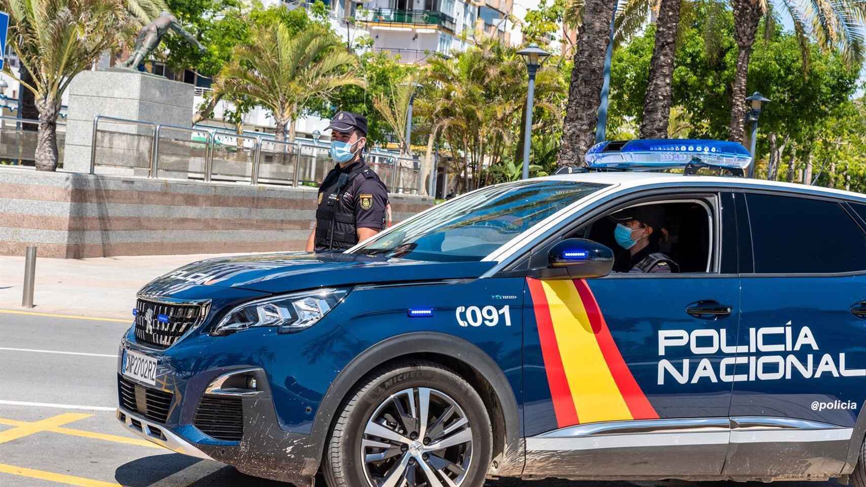Un coche y dos agentes de la Policía Nacional en Alicante, en imagen de archivo.