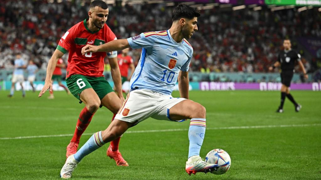 Marco Asensio se lleva el balón ante la presión de un jugador de Marruecos