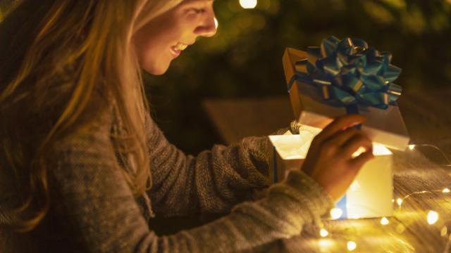 Una mujer abriendo su regalo de Navidad.