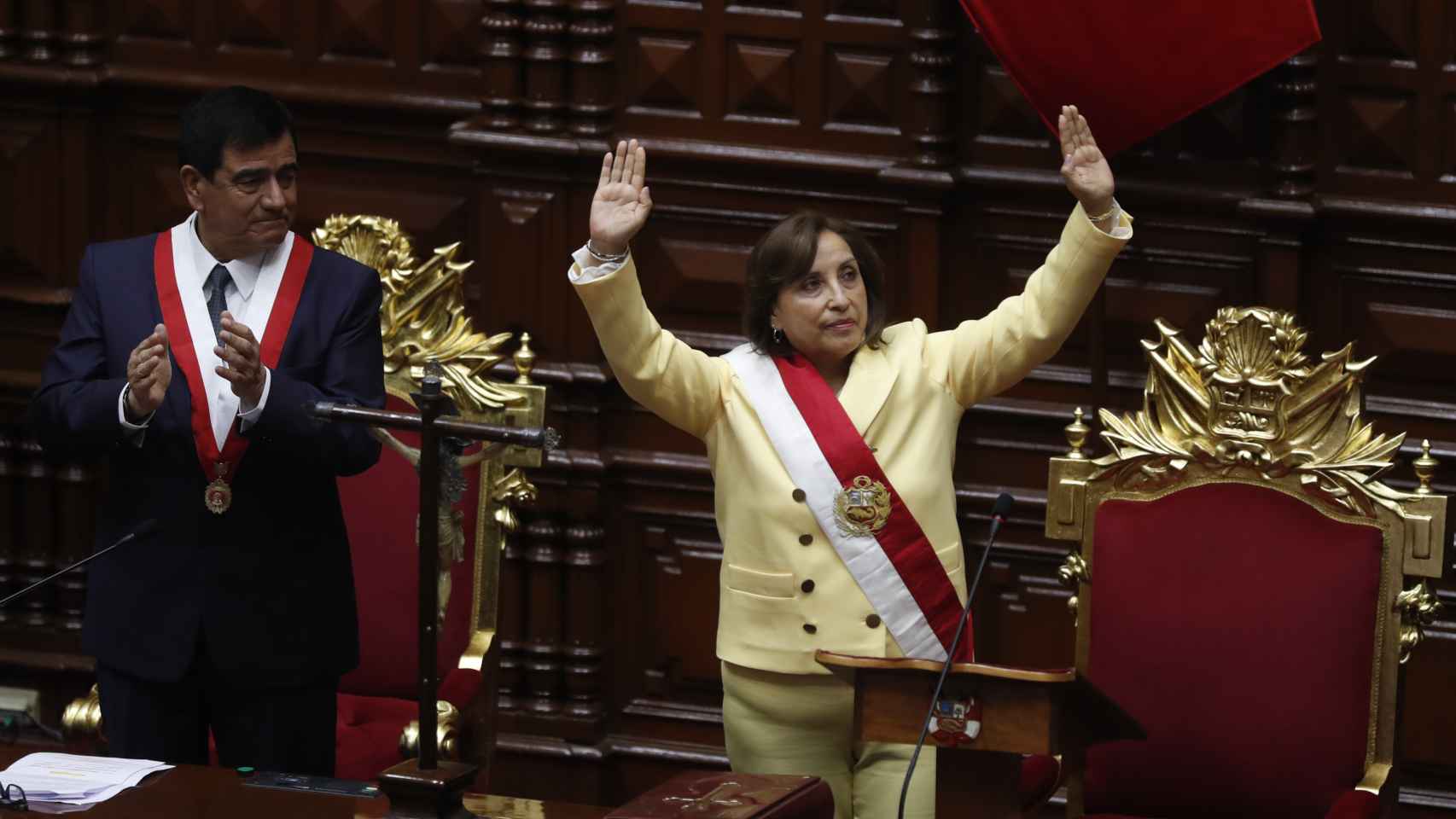 La abogada Dina Boluarte saluda tras jurar el cargo como nueva presidenta de Perú.