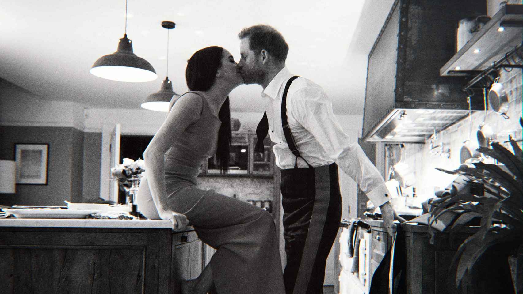 En una fotografía en blanco y negro, Harry y Meghan se besan en la cocina de su casa, en California.