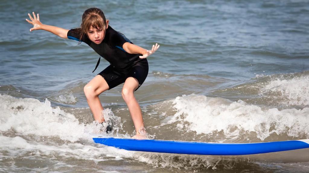 Niña practicando surf.