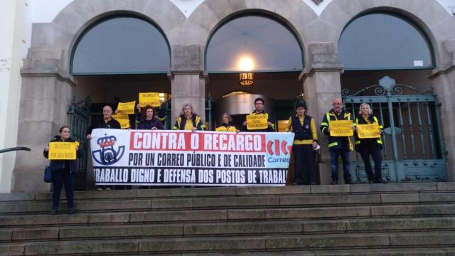 Trabajadores esta mañana ante la oficina de la plaza de Galicia