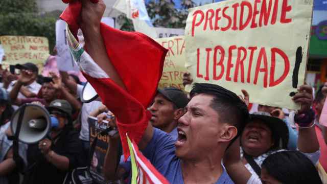 Un grupo de manifestantes sale a las calles de Perú contra la detención de Pedro Castillo.
