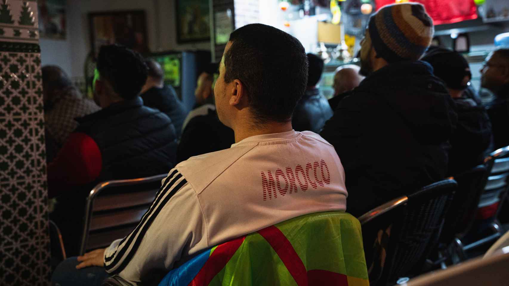 Un aficionado ve el partido con la camiseta de Marruecos y la bandera bereber.