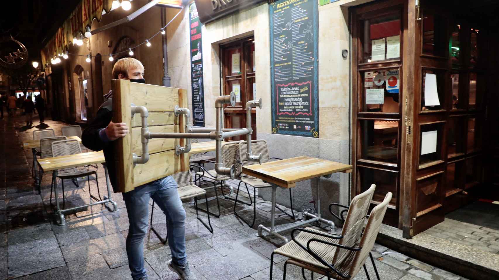 Un trabajador recoge la terraza de un establecimiento en Salamanca