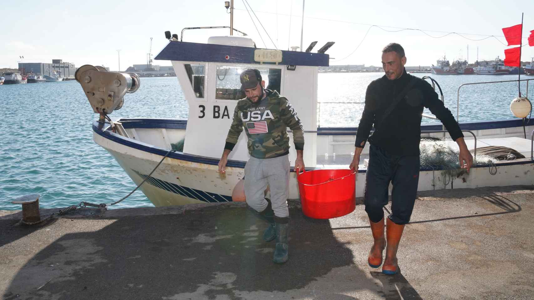 Los pescadores de la cofradía de Vilanova trasladan los organismos sésiles en un barreño.