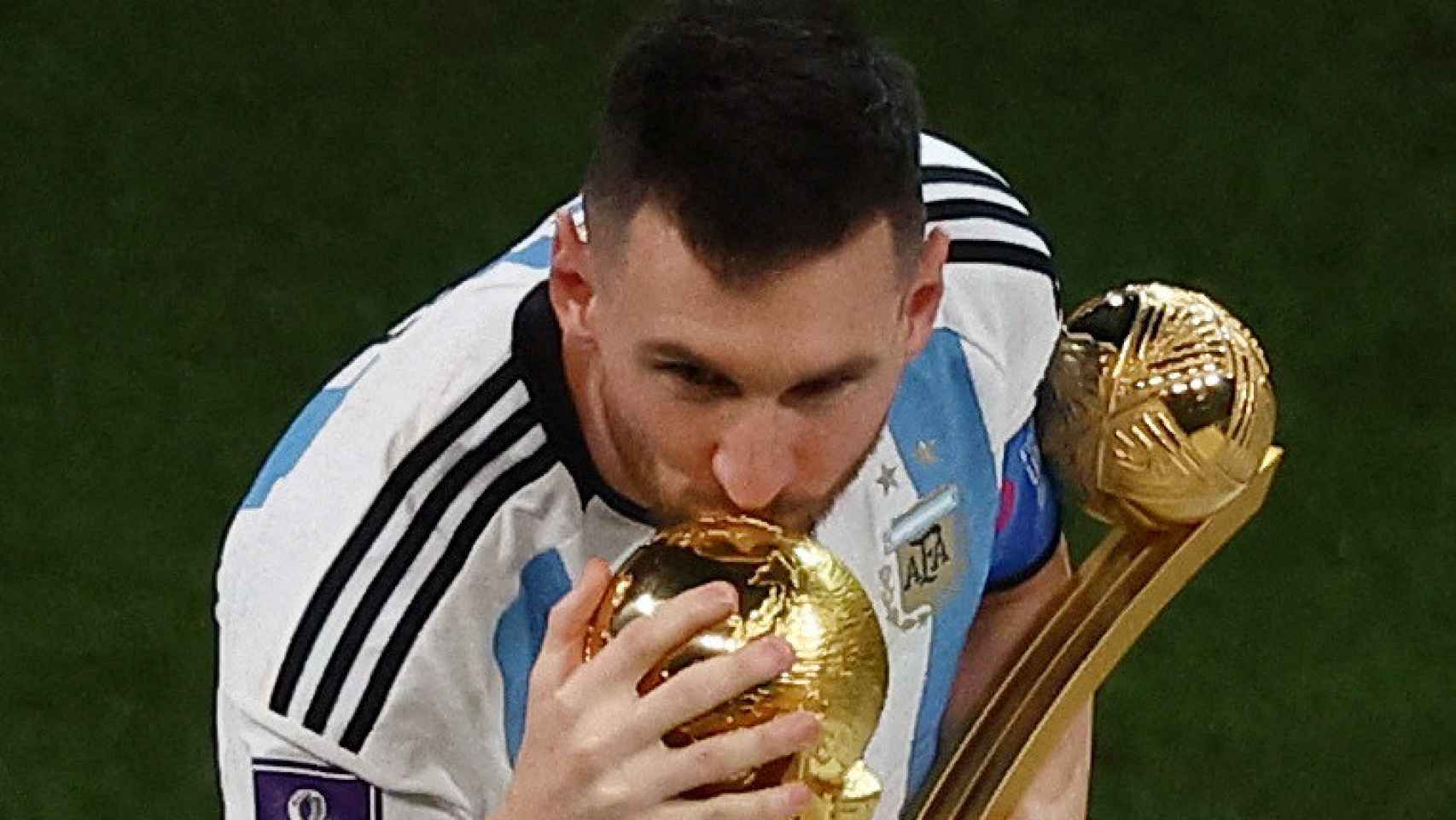 Leo Messi, con el Balón de Oro del Mundial en la mano, besando la Copa del Mundo
