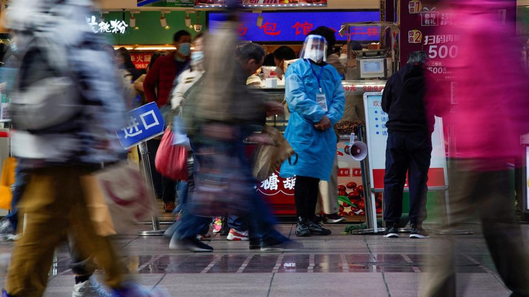 Un trabajador con EPI en un mercado de Shanghái.