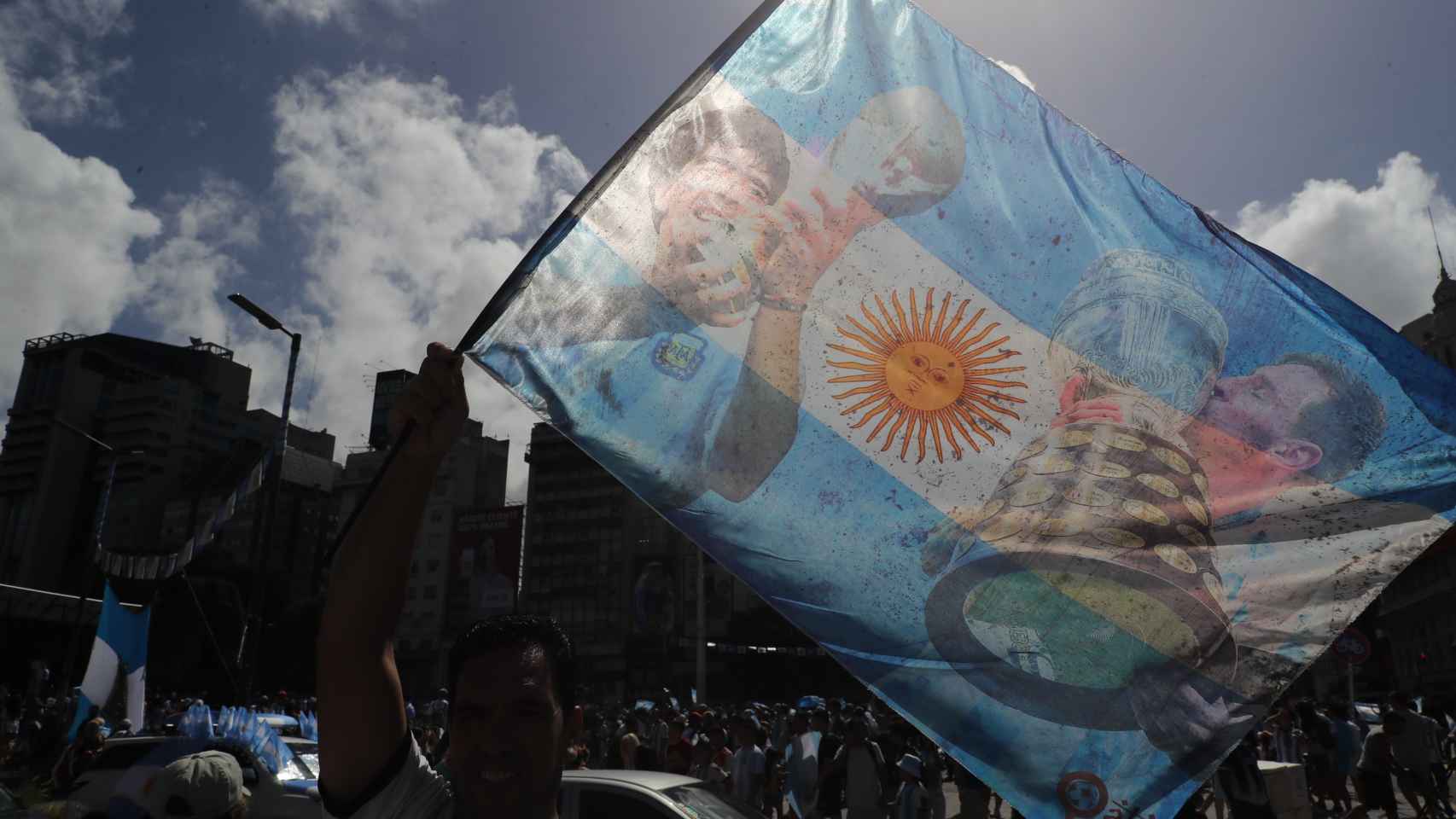 Un aficionado de Argentina celebra el título en el Mundial con una bandera albiceleste con Maradona y Messi