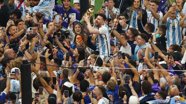 Leo Messi levantado por parte de su equipo y de fans en la celebración.