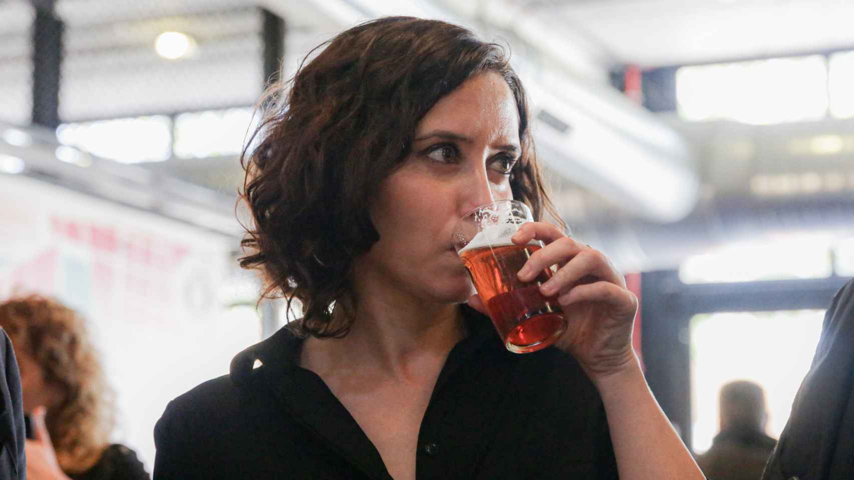 La presidenta de la Comunidad de Madrid, Isabel Díaz Ayuso, se bebe una caña de cerveza durante su visita a la fábrica de cerveza artesanal 'La Virgen', en Las Rozas (Madrid).