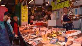 Varias personas esperan su turno para hacer la compra de Navidad en una pescadería de Valladolid