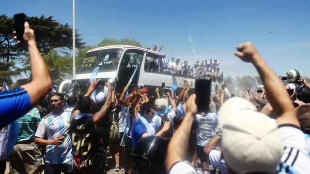 Varios aficionados argentinos, ante el paso del autobús de Argentina.