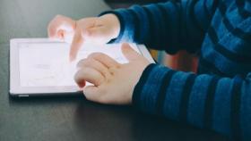 Un niño juega con una tableta.