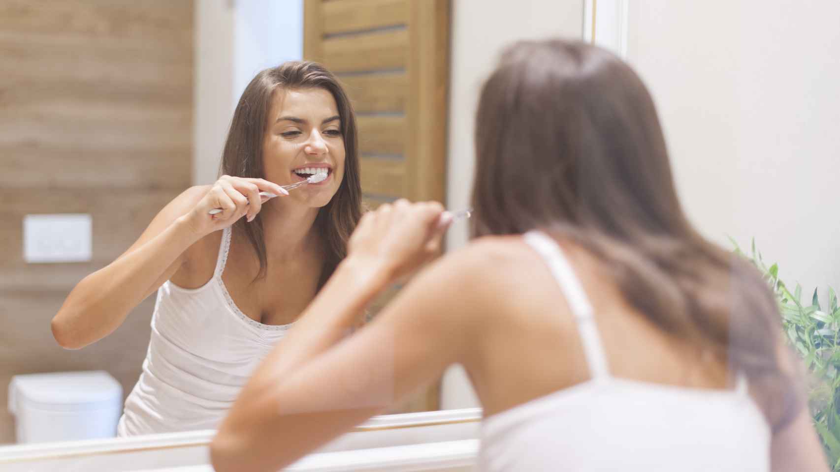 Una mujer, cepillándose los dientes.