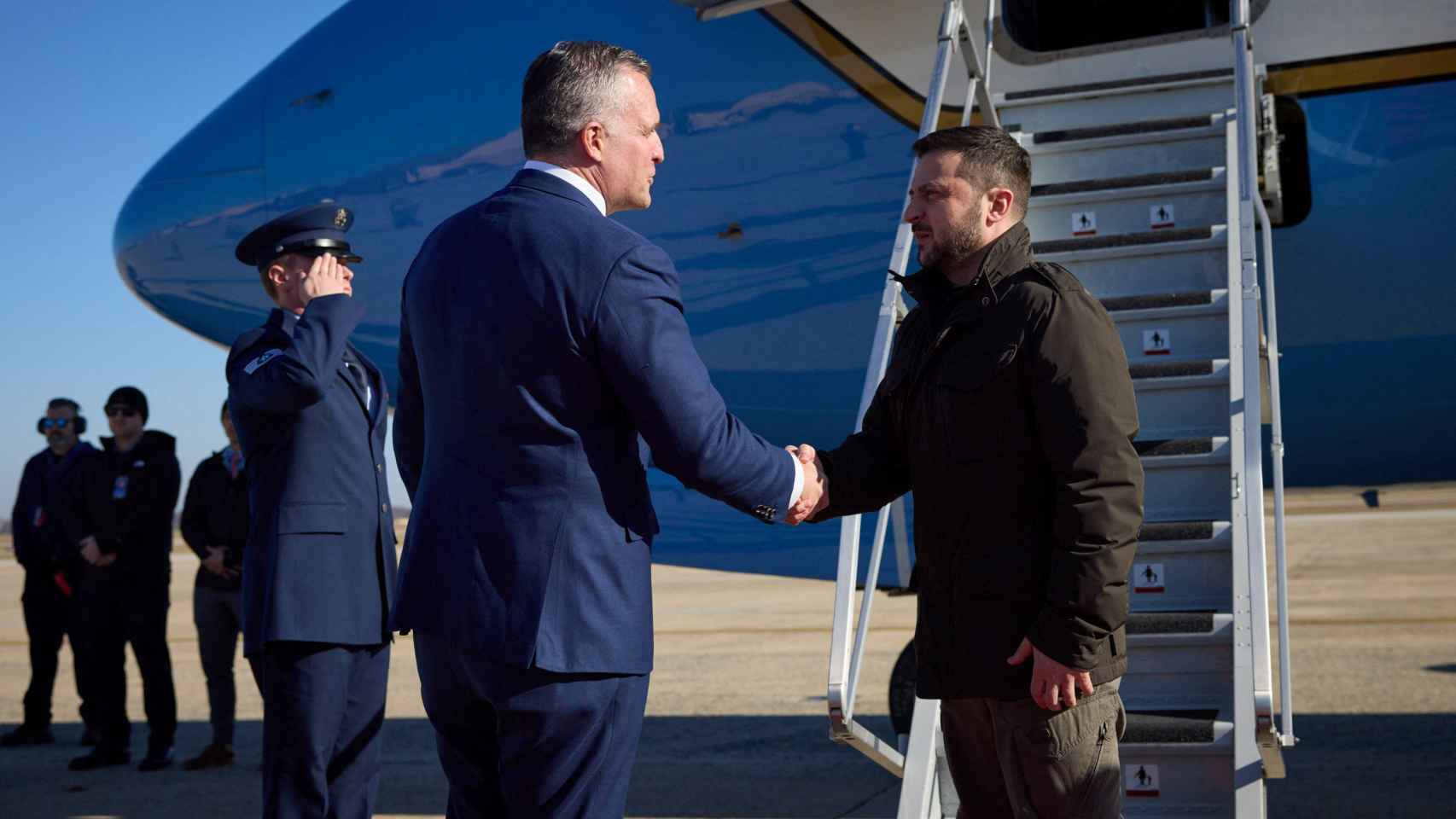 Zelenski llega a Washington y saluda al jefe de protocolo de EEUU, Rufus Gifford, que le ha recibido en el aeropuerto.