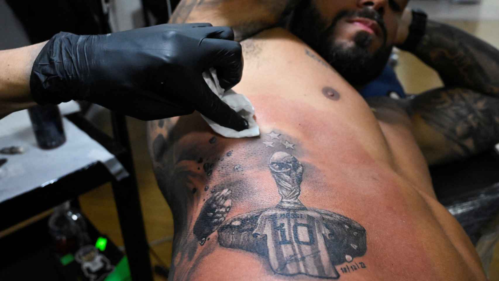 Una persona se tatúa a Messi con la Copa del Mundo.
