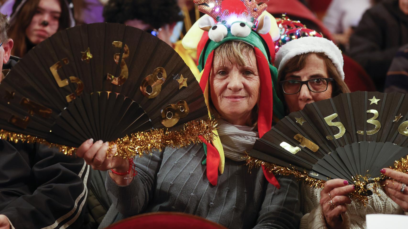 Varias personas disfrazadas esperan el comienzo del sorteo de la Lotería de Navidad.
