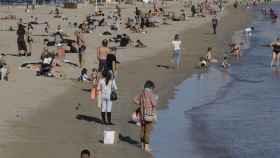 Un gran número de personas disfrutan del buen tiempo en la playa de El Postiguet de Alicante