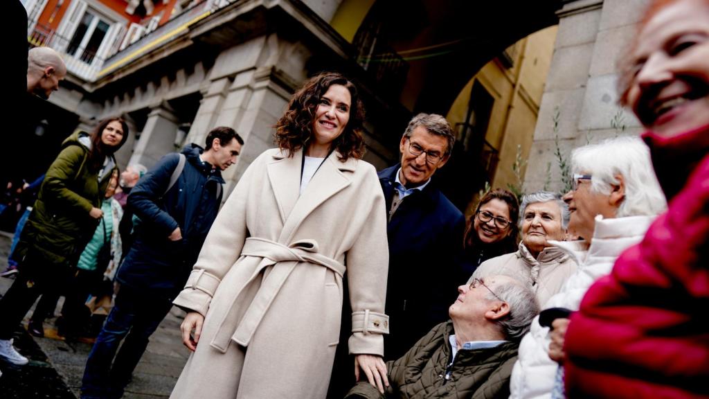 Ayuso y Feijóo en la entrada de la Plaza Mayor con un grupo de visitantes.