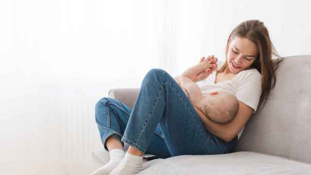 Una mujer dando el pecho a un bebé.