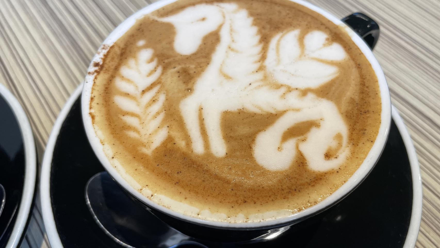 Un café con leche sobre el que se ha dibujado un pegaso.