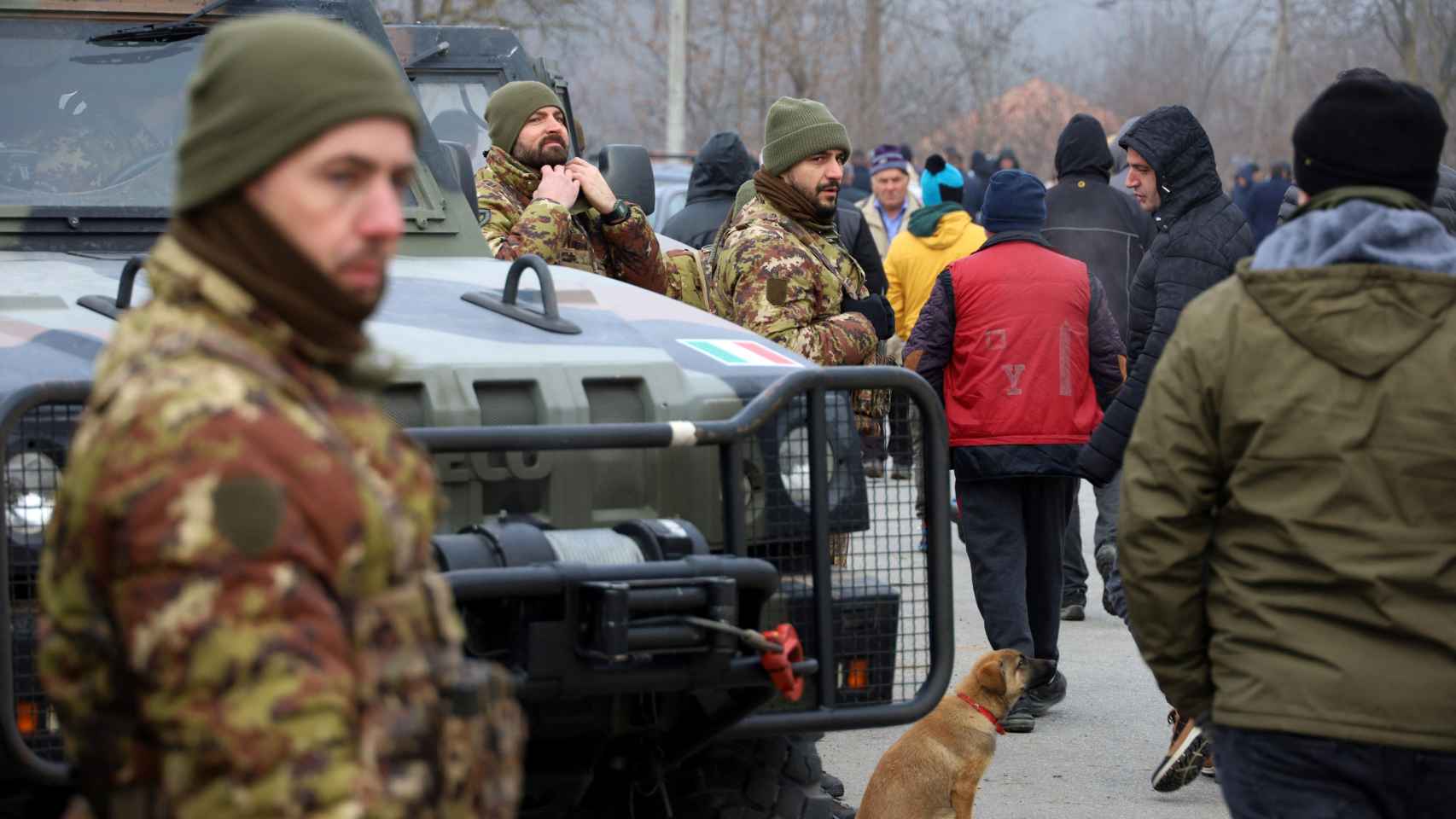 Los miembros de las Fuerzas Armadas Italianas, parte de la misión de mantenimiento de la paz de la OTAN en Kosovo, ven cómo los serbios locales protestan contra el gobierno cerca de un obstáculo en Rudare.