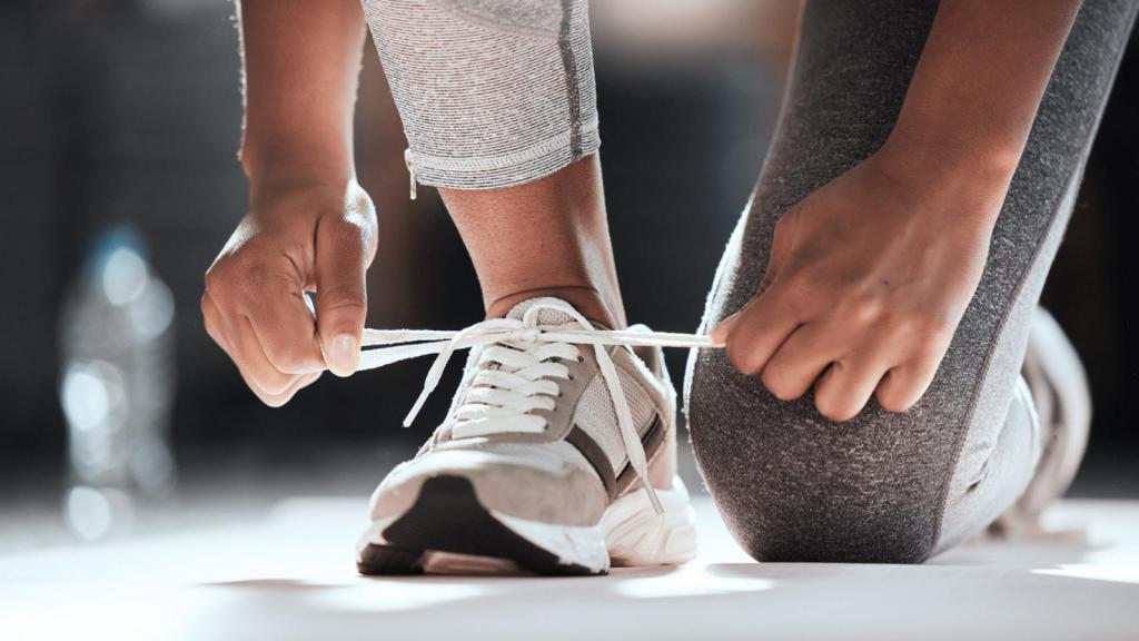 Una mujer ata sus cordones.