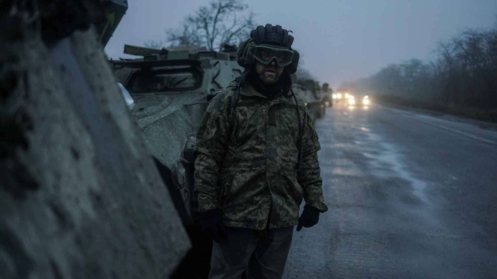 Un miembro del servicio ucraniano junto a un vehículo blindado de transporte en Jersón