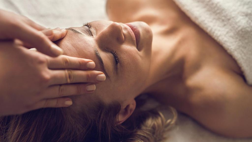 Una mujer, recibiendo un masaje facial.