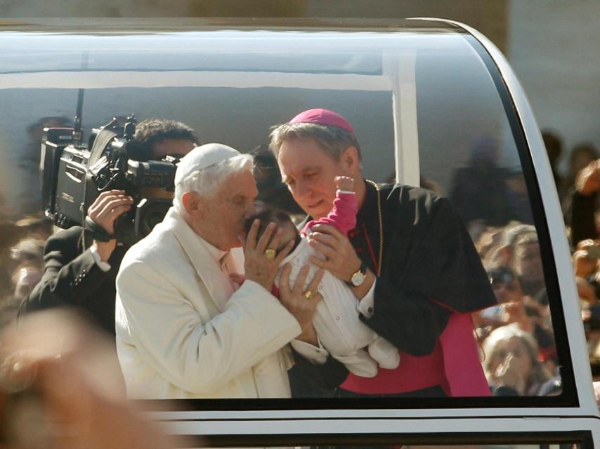 Benedicto XVI bendice a un bebé en la plaza de San Pedro, durante su última audiencia.