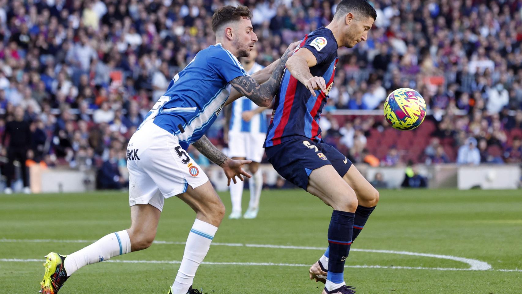 Robert Lewandowski, protegiendo el balón ante Fernando Calero en el derbi catalán de La Liga 2022/2023