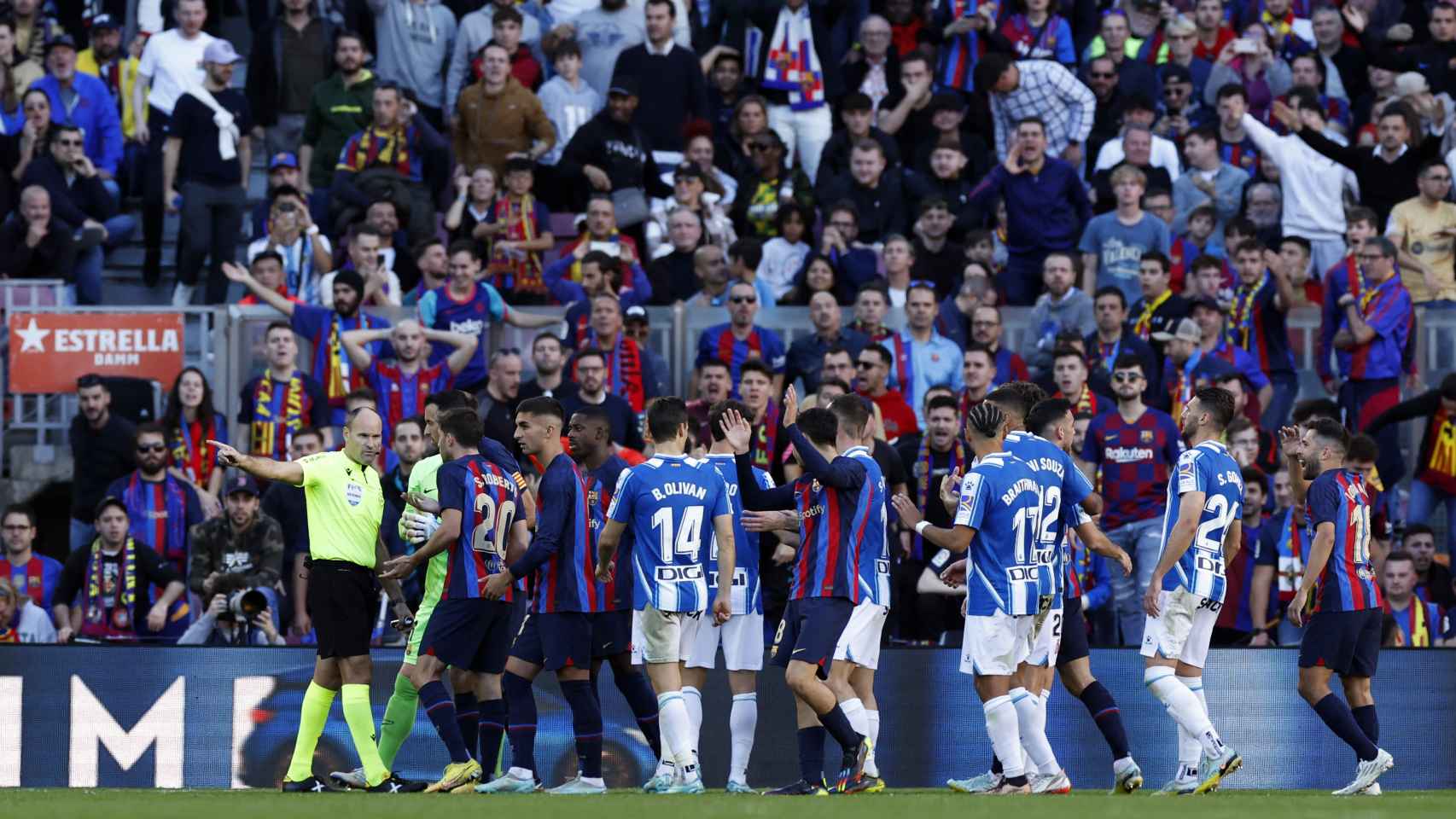 Mateu Lahoz, rodeado por los jugadores de Barcelona y Espanyol en el derbi catalán