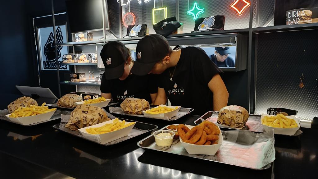 Dos trabajos de La Birra Bar, en Madrid, preparando los pedidos.