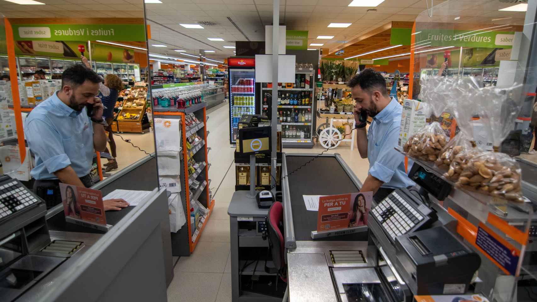 El encargado de un supermercado de Canonja (Tarragona) realizando una llamada desde una de las cajas del establecimiento.